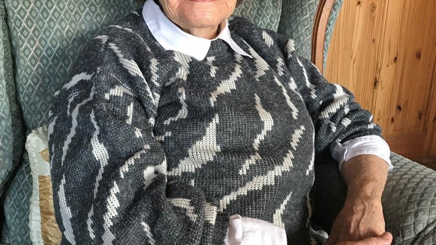 Photograph of blind veteran Neena, photographed at home sitting on an armchair