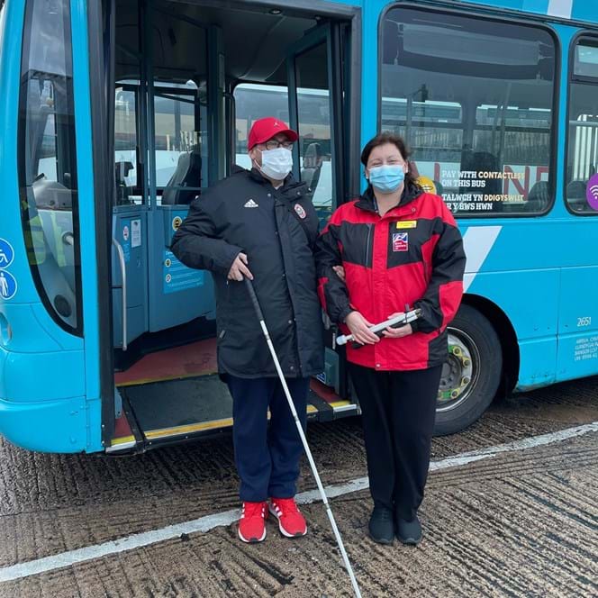 Blind veteran being helped off the bus by one of our Rehabilitation Officers