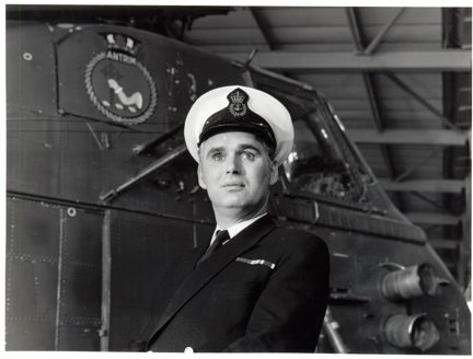 Photo of blind veteran, Terry Bullingham, in his Naval uniform standing in front of a vessel
