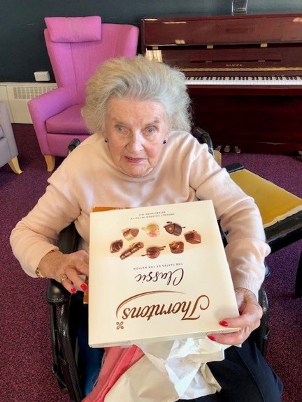 Blind veteran Maureen holding a Thorntons' Classic Collection box of chocolate