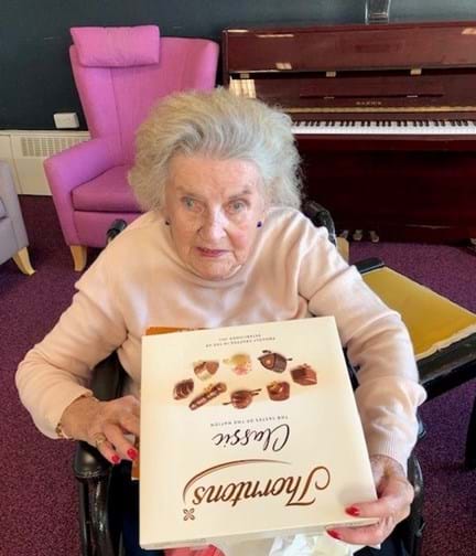 Blind veteran Maureen holding a Thorntons' Classic Collection box of chocolate