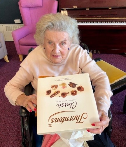 Blind veteran Maureen holding a Thorntons' Classic Collection box of chocolate