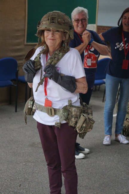 Jennie is wearing civilian clothes with a camo helmet and belt