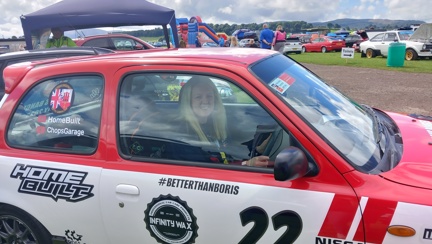 Nicola sat inside a red, white and blue Nissan Micra