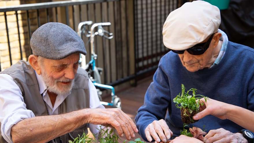 Photo of blind veterans Ken, left, and Richard, right, gardening 