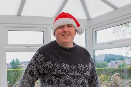 Blind veteran Chris wearing a Christmas hat and jumper