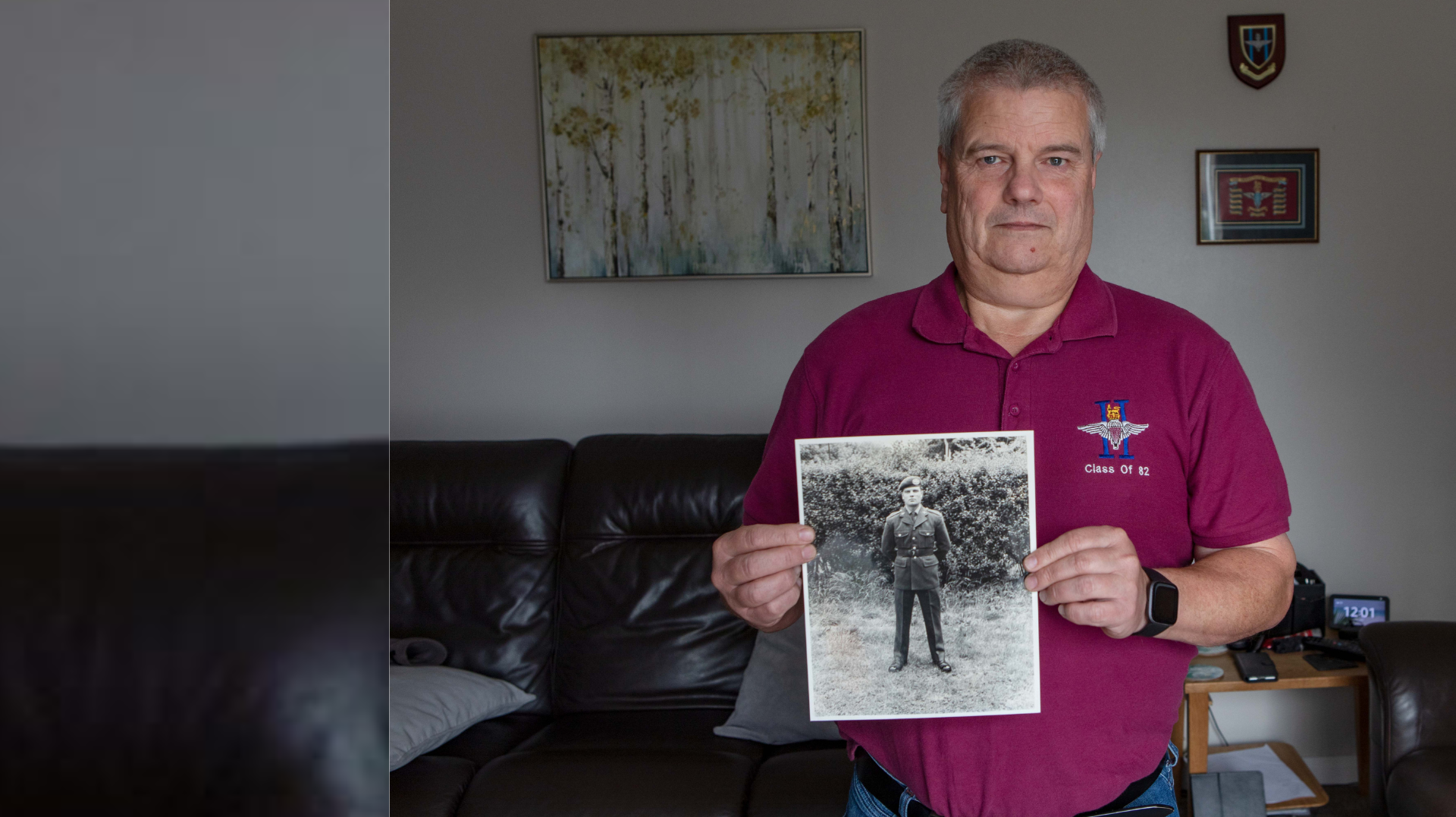 Blind veteran Steve holding a photo of him as a younger man in uniform