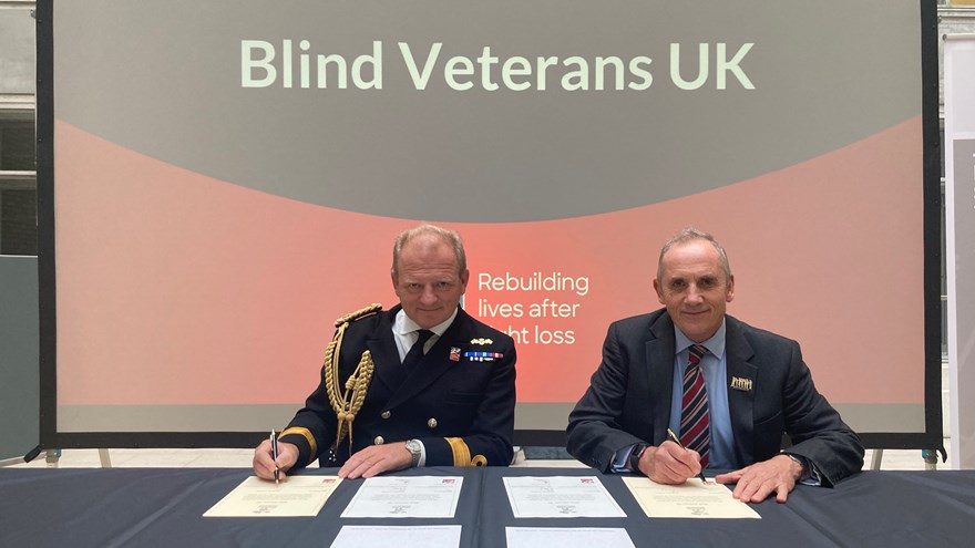 Photo of Commodore Bellfield On Behalf Of The Mod And Nick Caplin On Behalf Of Blind Veterans UK sitting signing the Armed Forced Covenant.