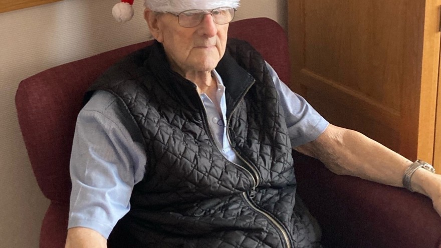 Blind veteran Harry sitting down, wearing a Christmas hat 