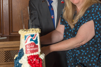 Blind veteran Billy, left, and Kathy, Centre Manager, right, cutting into a Blind Veterans UK cake