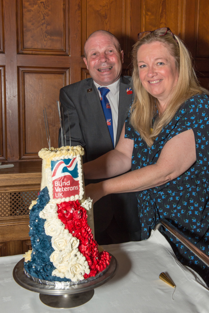 Blind veteran Billy, left, and Kathy, Centre Manager, right, cutting into a Blind Veterans UK cake