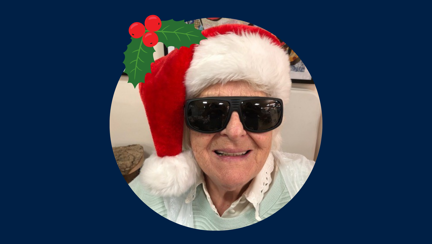 Blind veteran Betty wearing a Christmas hat and dark glasses, detailed with an illustration of holly.