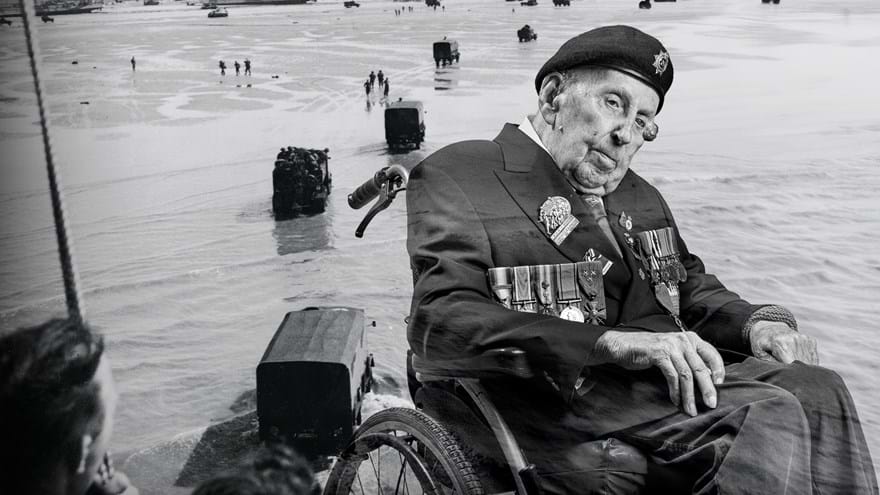 A black and white portrait of Ken, overlaid on a D-Day scene