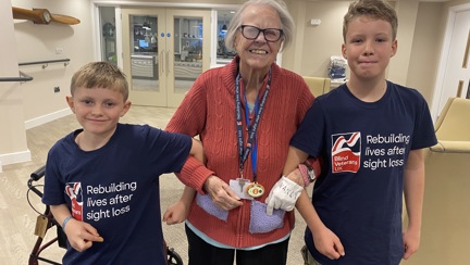 Sammy and Oakley stood either side of Nancy linking arms and all smiling. Photo taken inside the Rustington Centre