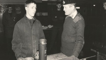 A black and white picture of Chris wearing overalls while at work 