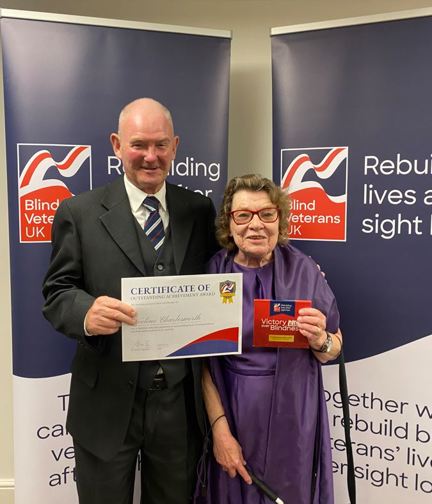 Noeline and John holding her certificate at Founder's Awards 2023