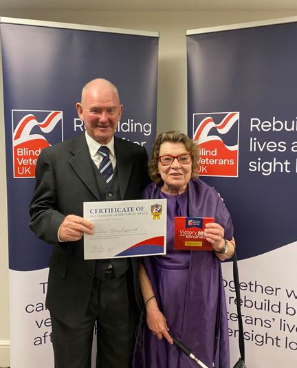 Noeline and John holding her certificate at Founder's Awards 2023