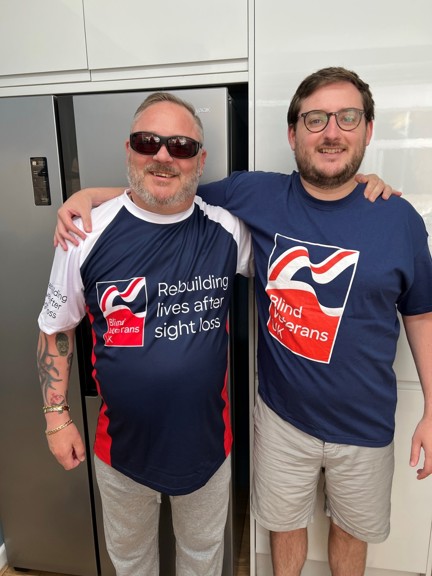 Chris and his son in Blind Veterans UK t-shirts with their arms around each others shoulders