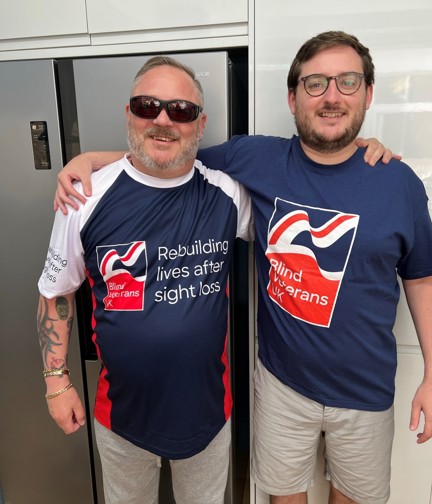 Chris and his son in Blind Veterans UK t-shirts with their arms around each others shoulders