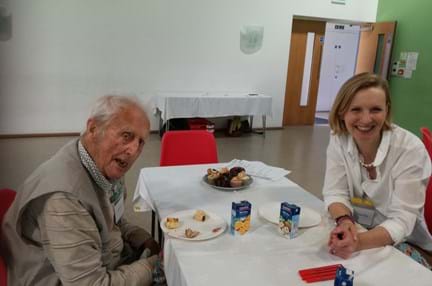A photo of blind veteran Len, left, and volunteer Claire, enjoying a chat and cake