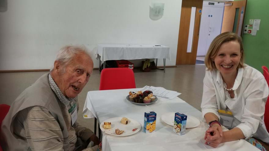 A photo of blind veteran Len, left, and volunteer Claire, enjoying a chat and cake