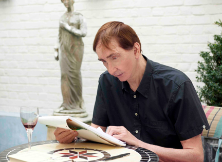 Blind veteran Robert sitting at a table looking over notebook