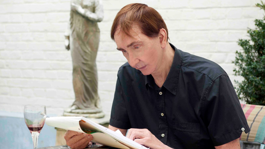 Blind veteran Robert sitting at a table looking over notebook