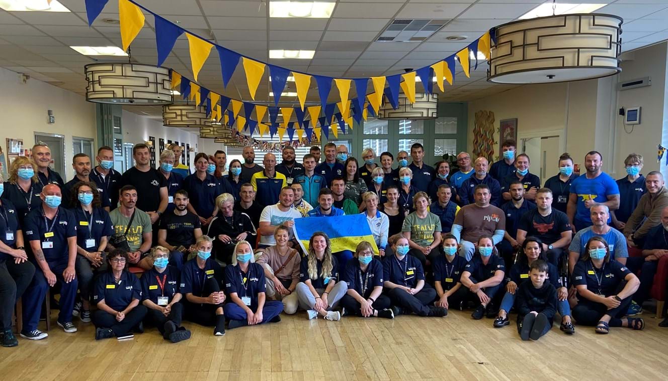 Group picture of Ukraine team with Blind Veterans UK staff sat under blue and yellow bunting