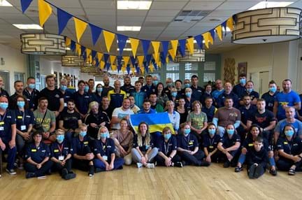Group picture of Ukraine team with Blind Veterans UK staff sat under blue and yellow bunting