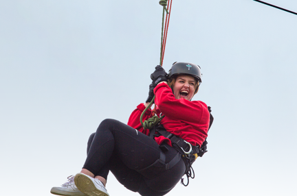 A photo of a girl going down a zip wire