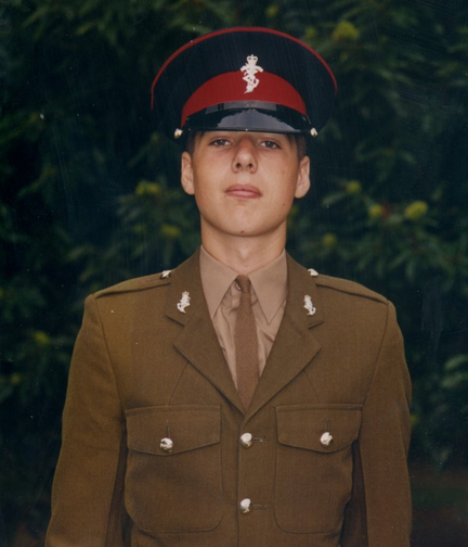 A young Simon standing proudly in his Army uniform