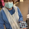 Blind veteran Sheila holding a square mosaic piece in tiles of different shades of blue