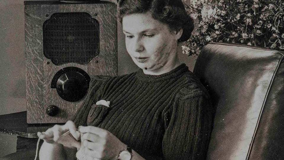 A black and white photo of Barbara Bell a blind veteran sewing