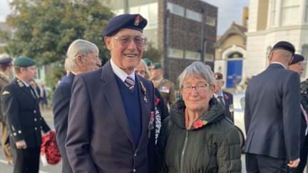 A photo of blind veteran Bob and wife Margaret holding wreath at Remembrance ceremony