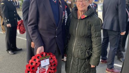 A photo of blind veteran Bob and wife Margaret holding wreath at Remembrance ceremony