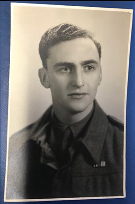 A black and white portrait of a young John during his days of service wearing his military uniform