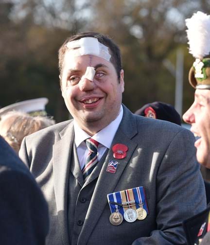 A photo of Simon wearing his medals at a Remembrance event in London in 2016