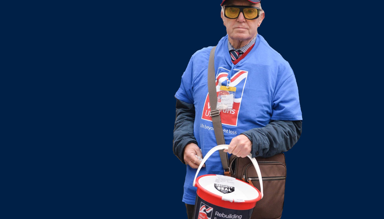 A photo showing blind veteran and volunteer Kenneth holding a collection bucket