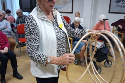 A lady wearing simulation glasses, holding hoops to play a game