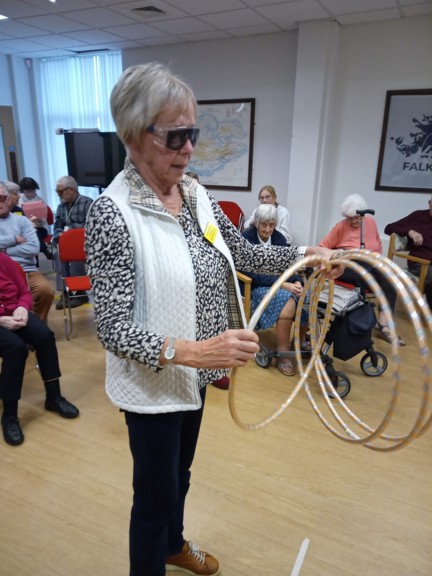A lady wearing simulation glasses, holding hoops to play a game
