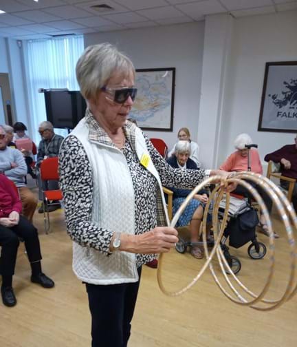 A lady wearing simulation glasses, holding hoops to play a game