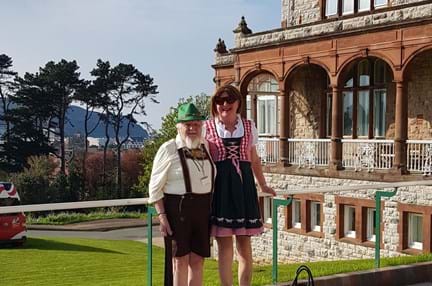 Michelle and Brian wearing German style clothing stood in front of the Llandudno Centre