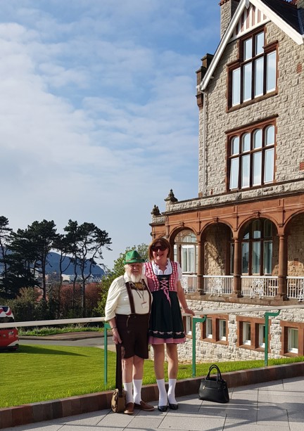 Michelle and Brian wearing German style clothing stood in front of the Llandudno Centre