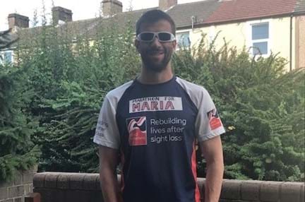 Darren stood in his garden wearing his Blind Veteran UK running top 