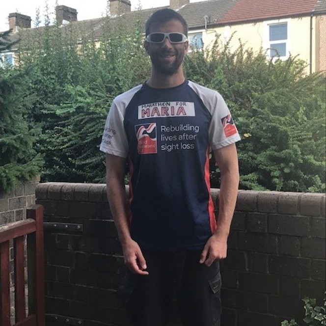 Darren stood in his garden wearing his Blind Veteran UK running top 