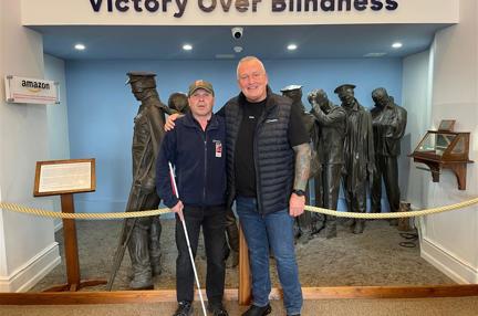 Billy and Colin stood in front of the Victory over Blindness statue at the Llandudno Centre