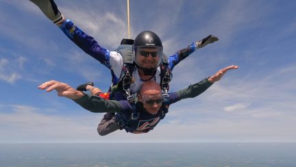 Mark and the tandem instructor gliding towards the ground with the parachute open