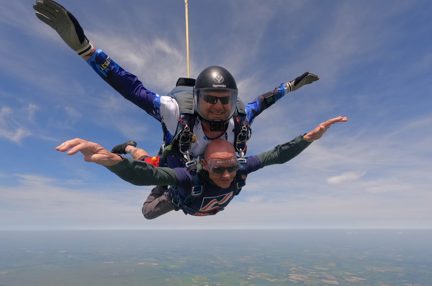 Mark and the tandem instructor gliding towards the ground with the parachute open