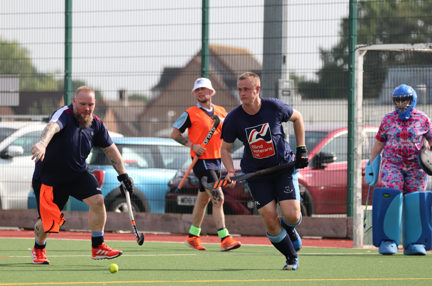 Player running towards the ball wearing a Blind Veterans UK t-shirt