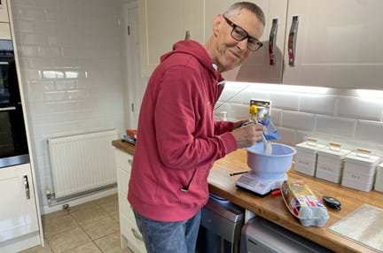 Blind veteran Mike in his kitchen using specially adapted equipment to bake